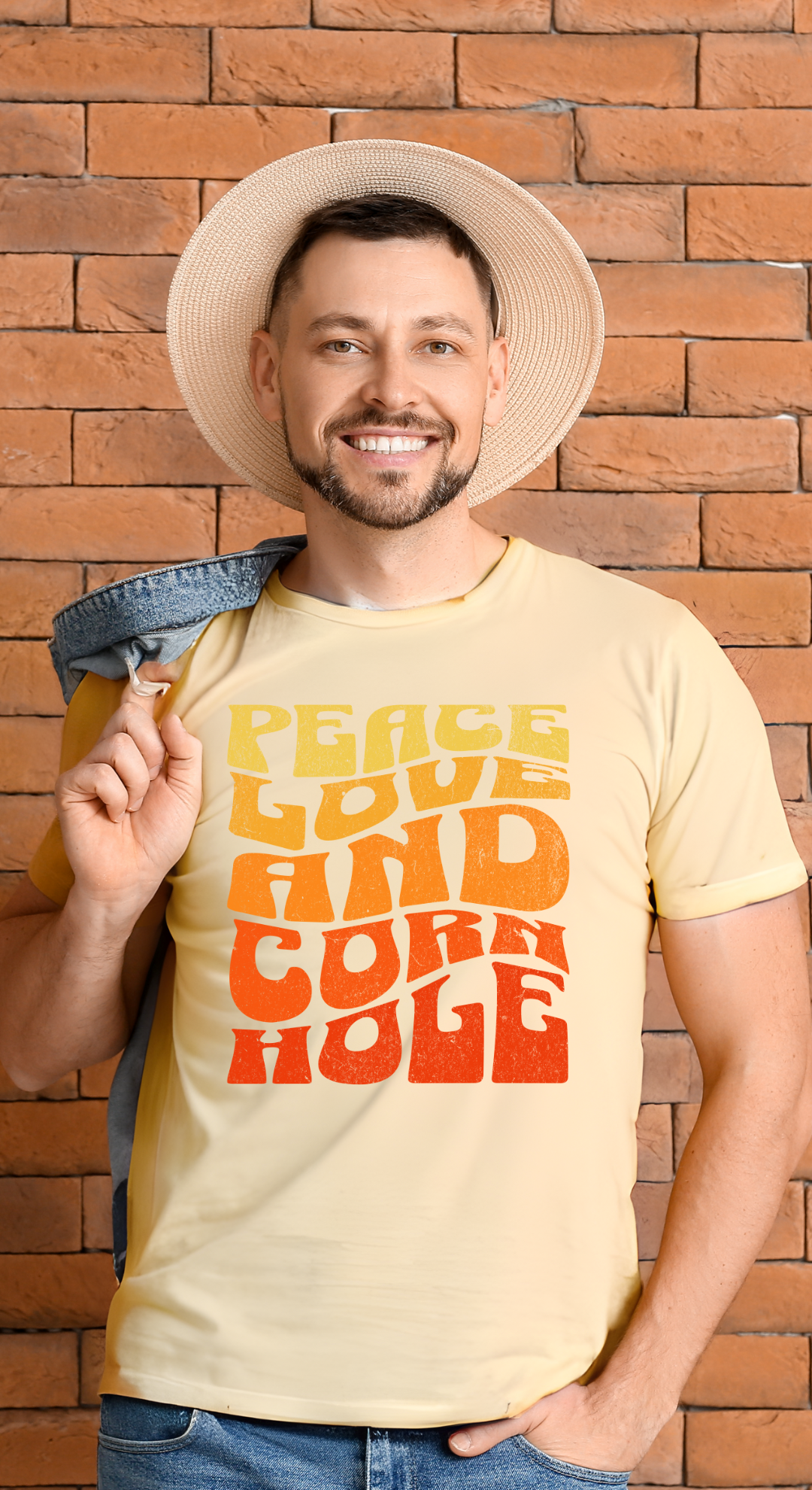 Man in hat wearing Peace Love and Cornhole Groovy Boho Soft Cotton Bella Canvas Tee Cornhole T-Shirt (Unisex)
